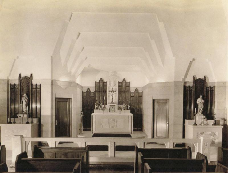 A view of the front of the chapel in the Mundelein College Skyscraper. The first three rows of pews are visible.