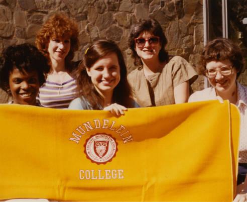 Five Mundelein College students hold a banner that says "Mundelein College."