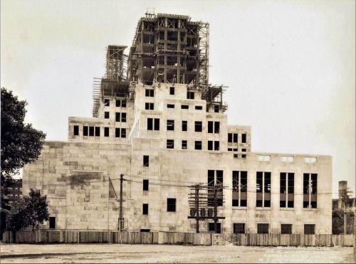 View of the construction of the Mundelein College Skyscraper. The lower floors look complete, while the upper floors are surrounded by scaffolding. 