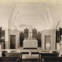 A view of the front of the chapel in the Mundelein College Skyscraper. The first three rows of pews are visible.